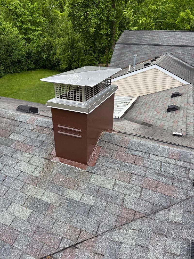 The same chimney chase painted brown with a new stainless chase cover and cap